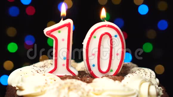 十号在蛋糕上面十号生日蜡烛燃烧在最后吹灭彩色模糊背景视频的预览图