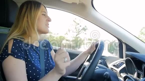 快乐的年轻女子开车唱歌的慢镜头视频的预览图