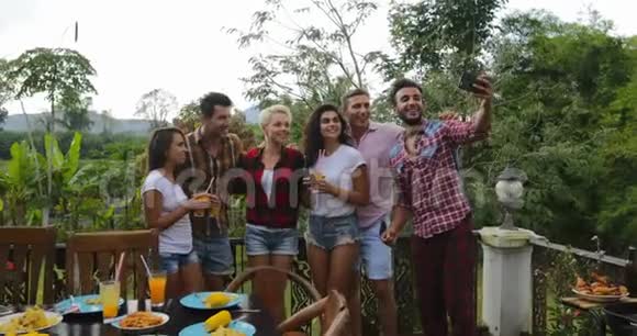 青少年利用手机烹饪自助拍照烧烤之友小组在夏日露台上聚会聊天视频的预览图