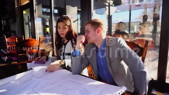 年轻设计师与景观工程和文件在咖啡桌视频的预览图