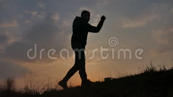 男子剪影拳自然格斗无规则概念在夕阳下的生活方式中打体育拳击剪影视频的预览图