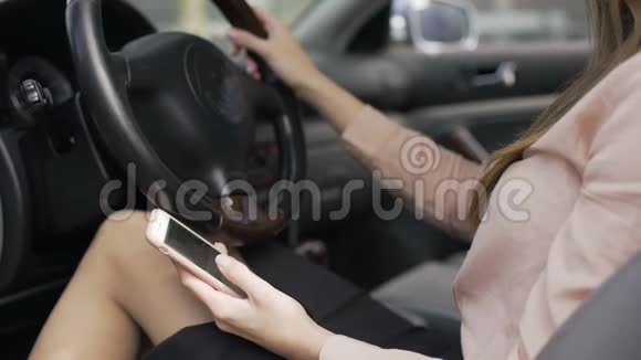 女商人坐在车里在智能手机移动应用程序上滚动新闻视频的预览图