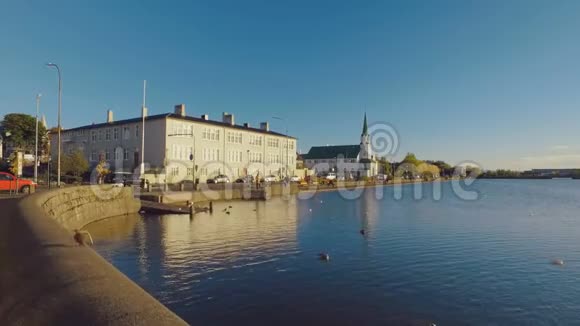 移动射击在阳光明媚的日子沿着雷克雅未克中心的Tjornin湖散步视频的预览图