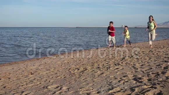 三个孩子在埃及度假村海滩跑步慢跑视频的预览图