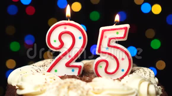 25号在蛋糕上面25岁生日蜡烛燃烧在最后吹灭彩色模糊背景视频的预览图