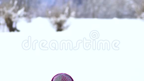 美丽的小女孩在雪地里玩耍玩得开心把雪扔上来视频的预览图