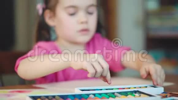 女孩在桌子上用蜡笔画画视频的预览图