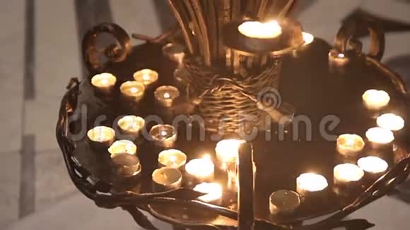 一种古老的金属烛台有燃烧的蜡烛在教堂里祈祷的地方视频的预览图