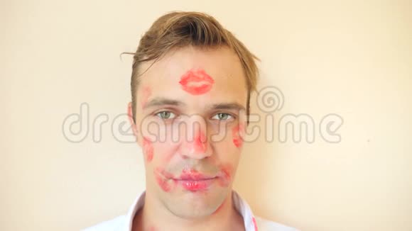 4k慢动作男人衣领上口红一个年轻人的肖像他整张脸上布满了吻的痕迹视频的预览图