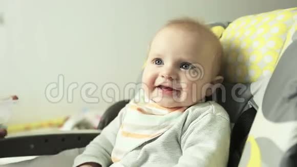 可爱微笑的小男孩在围兜里吃勺子粥的肖像视频的预览图