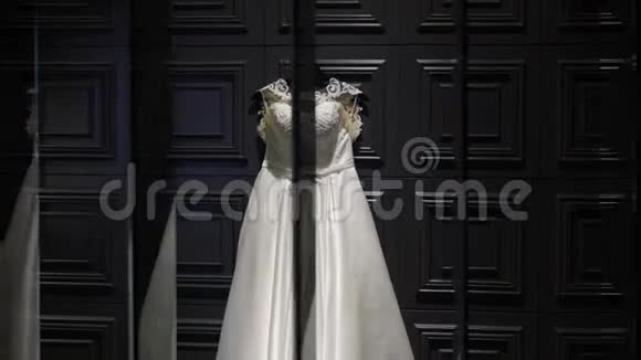白色婚纱在黑暗的墙上镜子里的倒影视频的预览图
