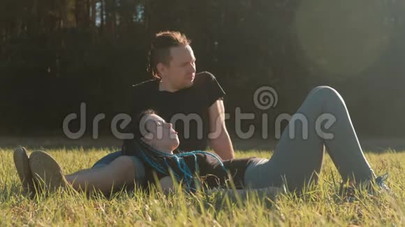几个情人在公园里放松躺在草地上聊天视频的预览图