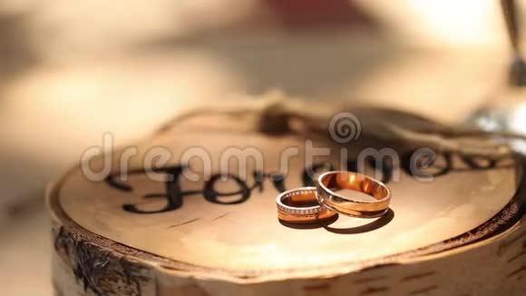 结婚戒指躺在树桩上木制的乡村风格铭文永远新郎和新娘的仪式上视频的预览图