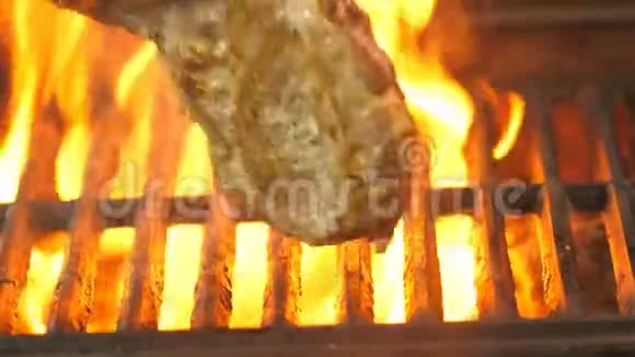 厨师用火钳转动烤架上的猪肉牛排看它炸了多少视频是特写的视频的预览图