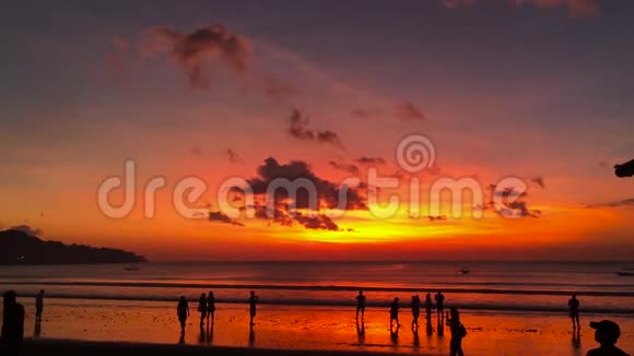美丽的日落在吉姆巴兰村的海滩上人的轮廓印度尼西亚巴厘视频的预览图