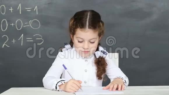 小女孩坐在学校的书桌旁视频的预览图