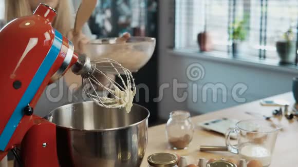 年轻迷人的女人在碗里加入配料打开搅拌机女性混合面团烘焙视频的预览图