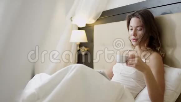 女人在床上用平板电脑喝咖啡视频的预览图