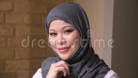 成年穆斯林女商人戴着头巾看着摄像机在工作场所的室内开心地微笑着的特写镜头视频的预览图