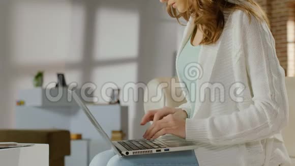 年轻女性工作在笔记本电脑上快速打字创业视频的预览图
