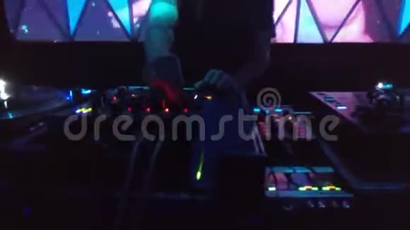 技术DJ转动一个旋钮和乙烯基唱片在技术俱乐部混合视频的预览图