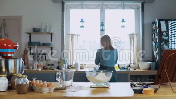 年轻漂亮的女人在家厨房做饭美丽的家庭主妇准备饭菜使用厨房秤视频的预览图