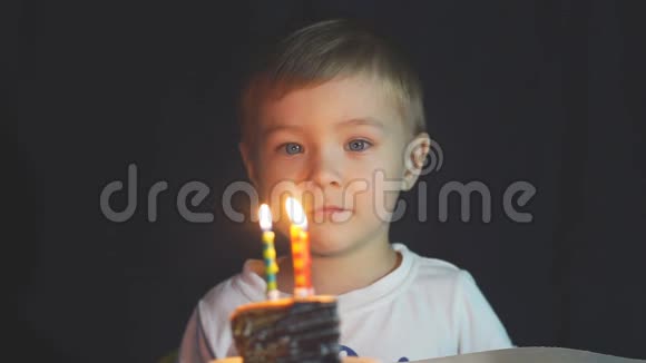 小男孩在聚会上吹灭生日蛋糕上的蜡烛视频的预览图