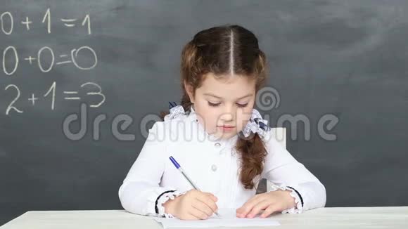 小女孩坐在学校的书桌旁视频的预览图