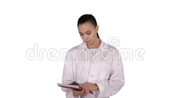 年轻的医生女士在白色背景下行走时阅读文件视频的预览图