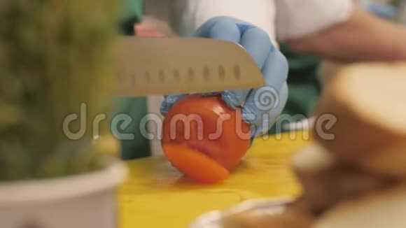 厨师用刀在餐厅切圆片和小块番茄视频的预览图