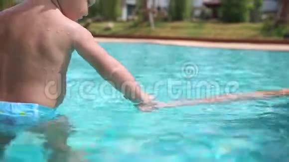 小女孩拉着妈妈的手指飞溅在游泳池里散步视频的预览图