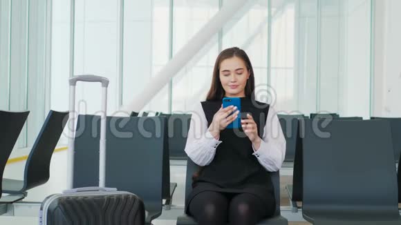 年轻漂亮的女人正在使用智能手机等待火车的到来年轻漂亮的金发女郎视频的预览图