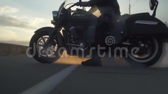 自行车在道路上的日落背景下用摩托车制造烟雾慢动作视频的预览图