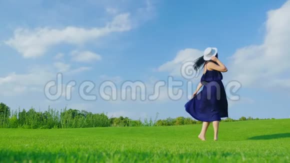 穿着浅色衣服的孕妇在绿色草地上玩得开心视频的预览图