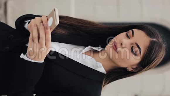 垂直视频聪明的城市年轻商务女性打电话女孩在智能手机上说话商业生活方式活跃视频的预览图