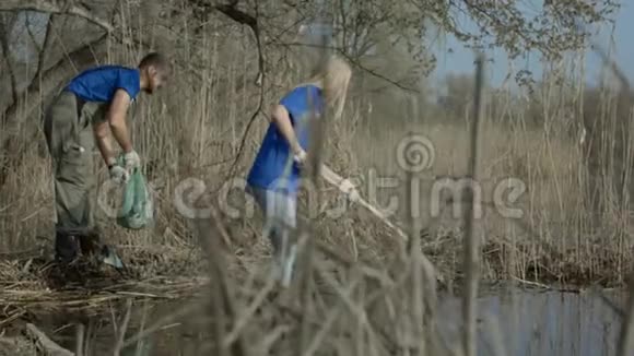 人们在树林里清理池塘岸边视频的预览图