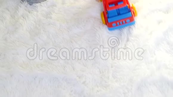 一个小孩在白色背景上缓慢地玩玩具卡车视频的预览图