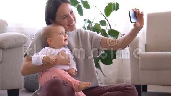 妈妈用手机和小女孩自拍视频的预览图