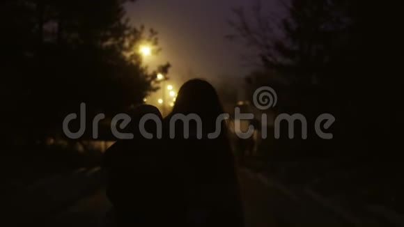 后景单身母亲牵着她的小儿子在手走在夜路上女人和小男孩一起移民视频的预览图