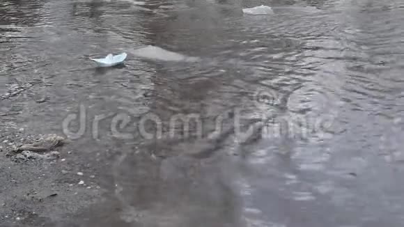 城市里的洪水路上有垃圾和纸船缓慢运动的泉水视频的预览图