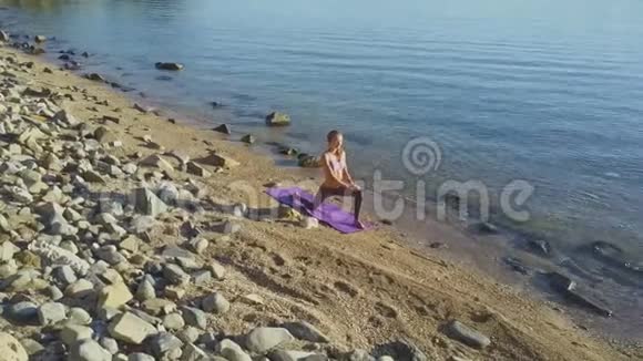 瑜伽姿势中的女孩在海洋中的运动视频的预览图