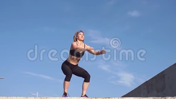 健身妇女蹲在户外锻炼慢动作视频的预览图