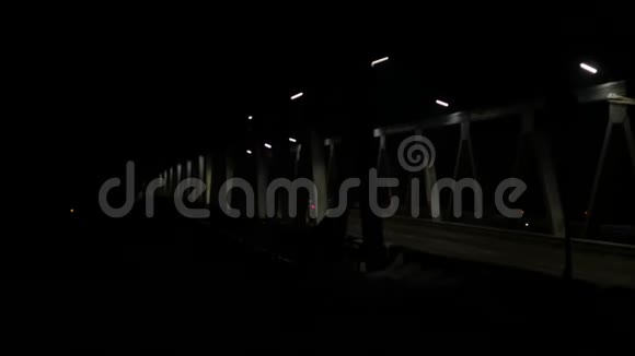 晚上有车流量的老铁桥经过的汽车的前照灯4K视频的预览图