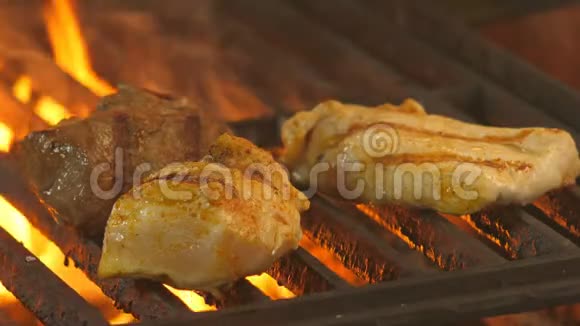 厨师用两个鸡肉片和一片小牛肉或牛肉在背景烤架上转动火钳来炸薯条视频的预览图