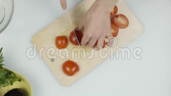 妇女使用菜刀滑切新鲜番茄在木切割板切番茄作生菜或披萨顶部视图视频的预览图