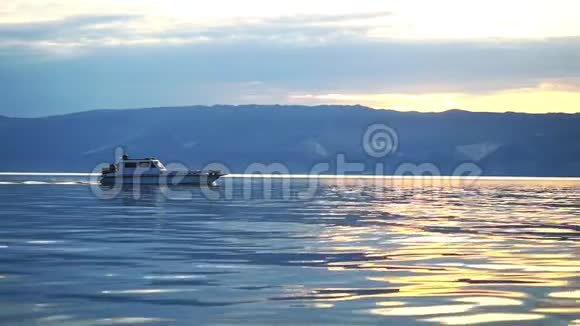 渔船在蓝色平静的湖在日落岛的背景慢动作1920x1080视频的预览图