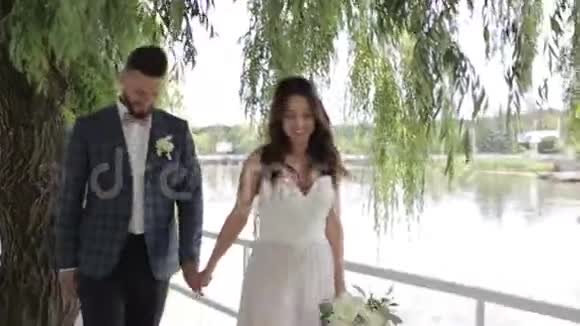 新郎新娘在湖边慢慢地走在一起视频的预览图
