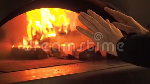 人在炉火旁温暖双手炉火壁炉燃柴的视频剪辑柴火在燃烧视频的预览图