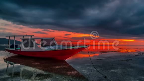 随着时间推移戏剧性的红色日落与关闭渔民船的轮廓靠近吉利航空岛伦博克印度尼西亚视频的预览图