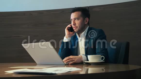 商务人员在办公室工作时用手机打电话视频的预览图